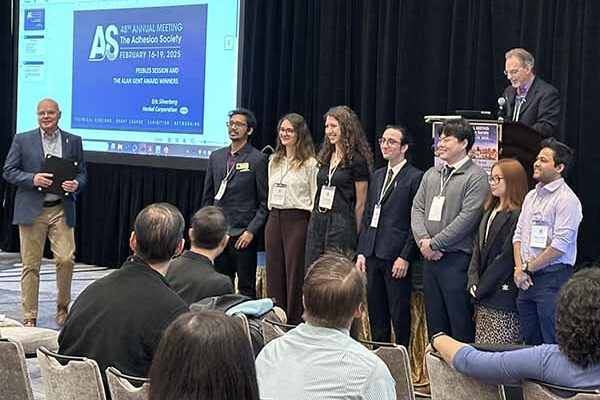 PhD students on stage lined up awaiting presentation of awards