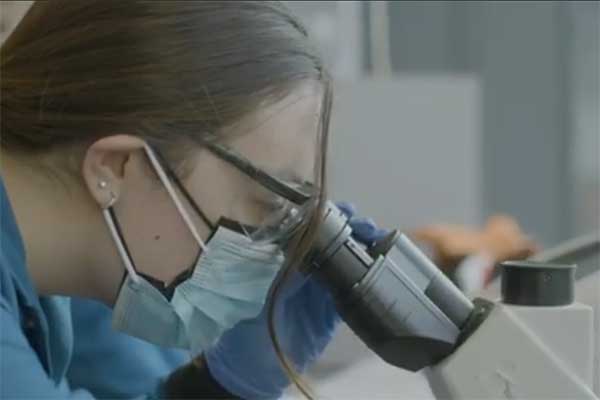 student looks into a microscope