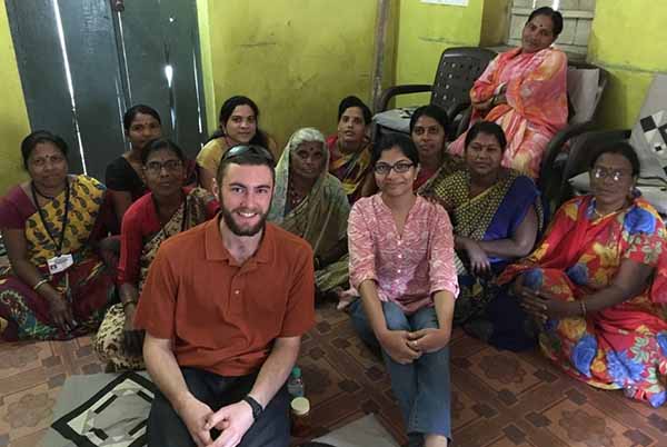 student sitting with group in India