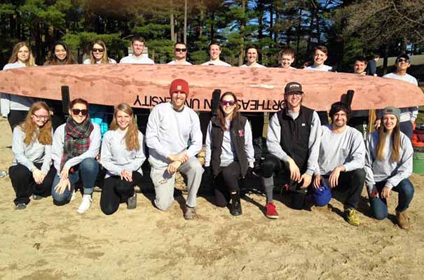 students posed in front of a concrete canoe