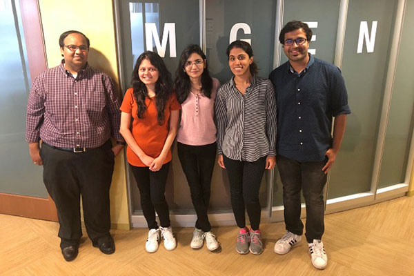 students and teacher in front of MGEN sign on campus