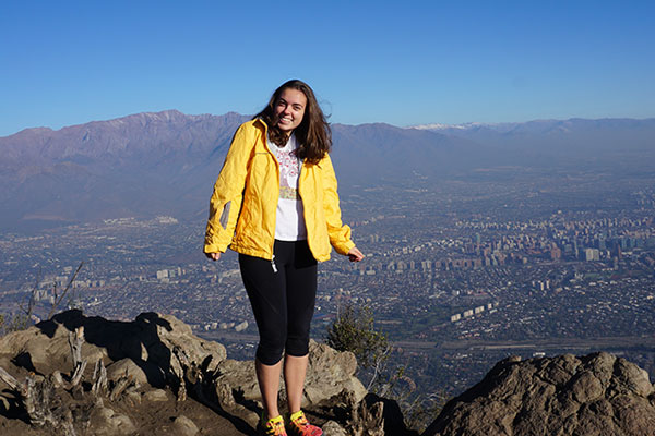 student overseas in Chile standing at top of mountain