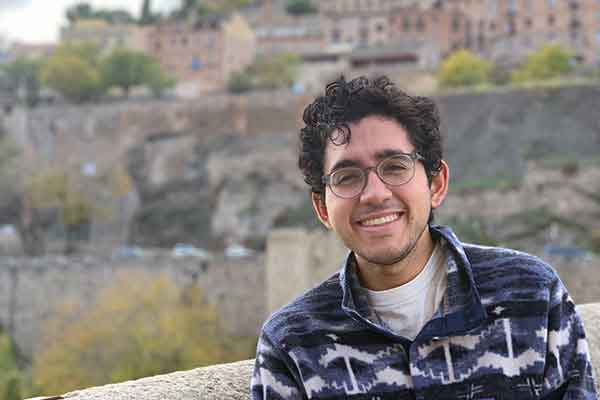student poses with international location in background