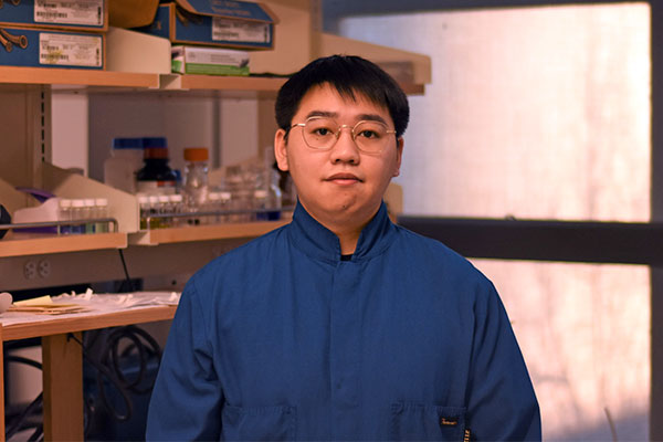 student portrait with mechanical engineering lab in background