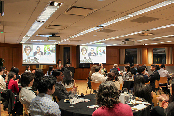 guests sitting at tables looking at the podium and projection screens
