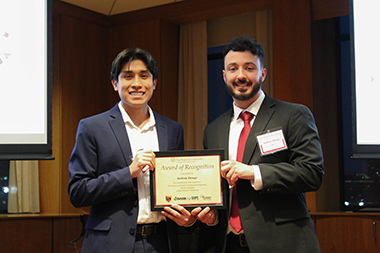 Andrew Abrego standing with a student holding an award