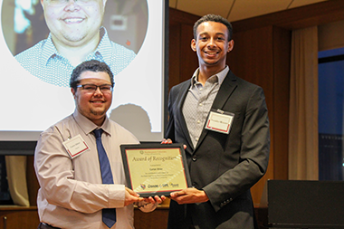 Carter Ithier standing with a student holding a staff award
