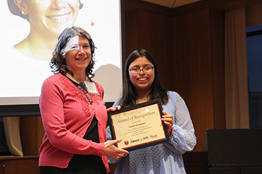 loretta fernandez stands with a student holding an award