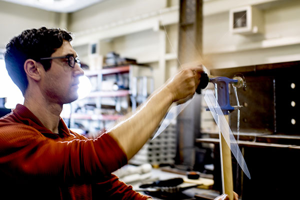 professor in lab turning a handle on wall equipment
