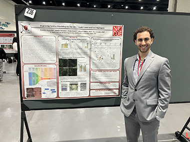 Dominic Pizzarella, chemical engineering student, standing next to his poster.