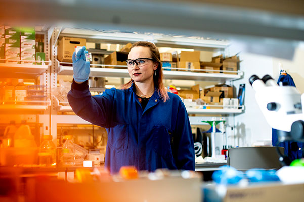 professor in chemical engineering lab holding tube