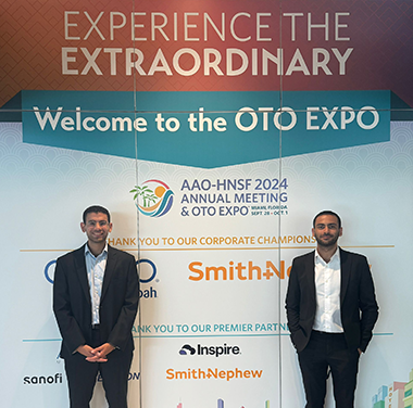 Bishoy Galoaa standing i front of a poster at the AAO-HNSK conference 