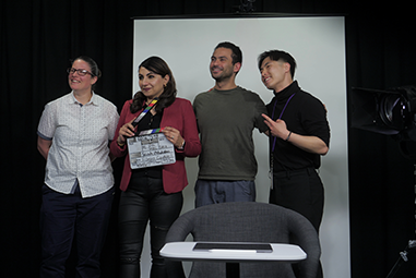 four people standing in front of a white backdrop