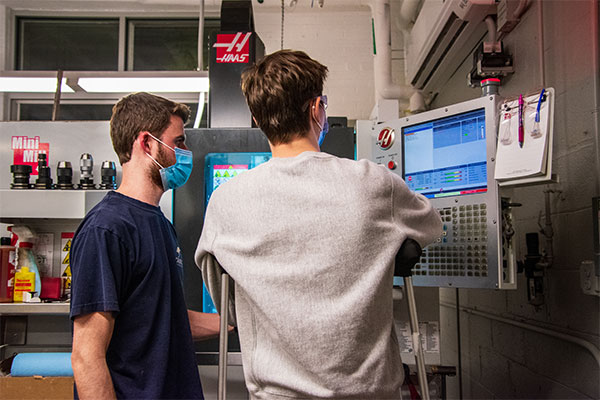 two students looking at computer screen in makerspace lab