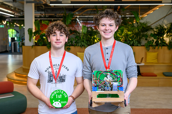 two students standing next to each other looking at the camera