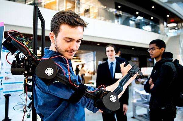 student tests out mechanical arm