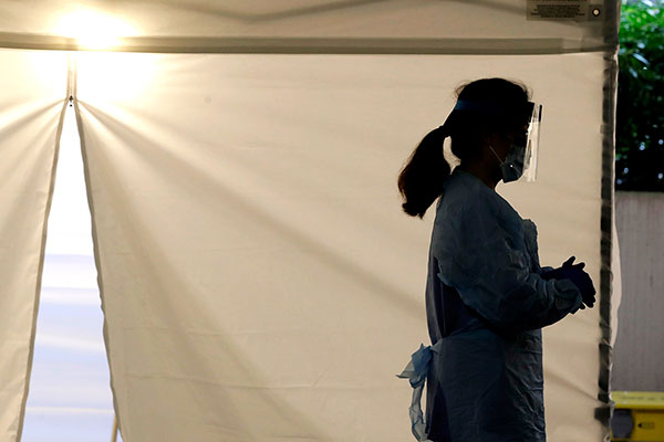 medical worker with face shield outside of medical tent