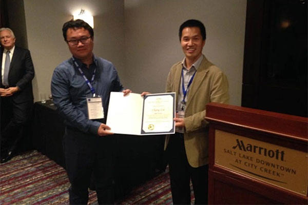two students showing their award